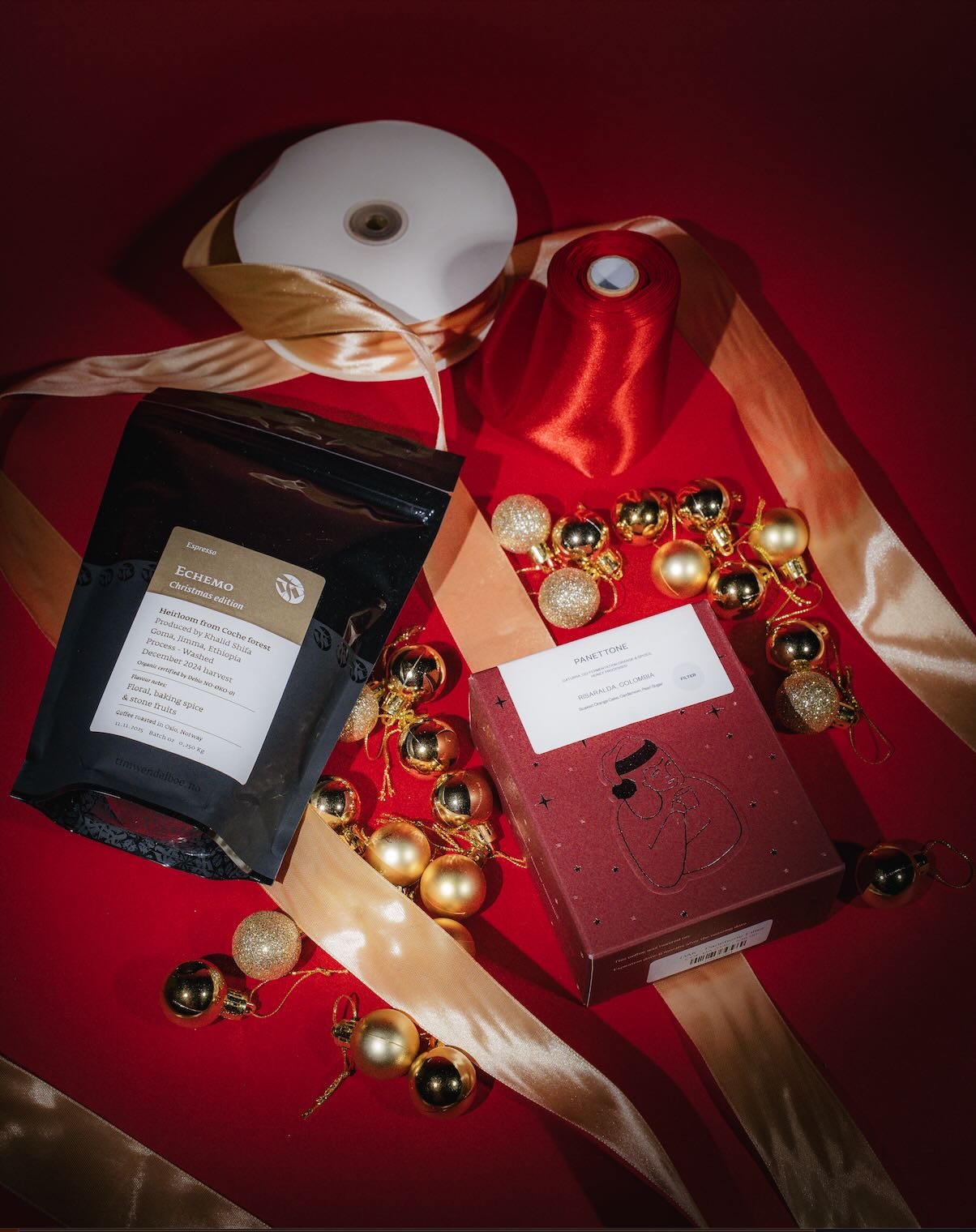 Boxes of DAK and Tim Wendelboe coffee against a red background with gold ribbons